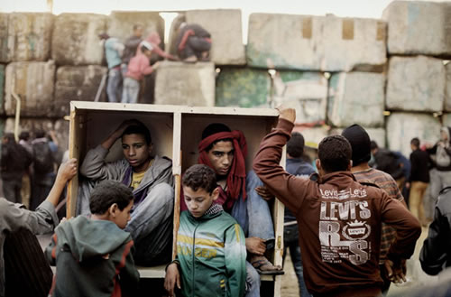 Jóvenes manifestantes se protegen de los combates que tienen lugar en la plaza de Tahrir. El Cairo (Egipto). Enero de 2013, por Moises Saman.